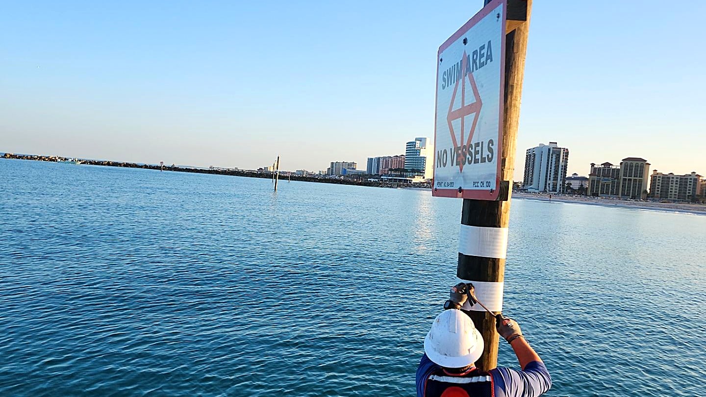 Marine safety crew installing buoy marker on government waterway